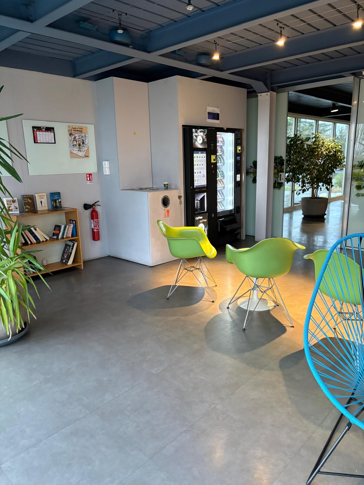 Espace commun lumineux avec fauteuils et distributeurs